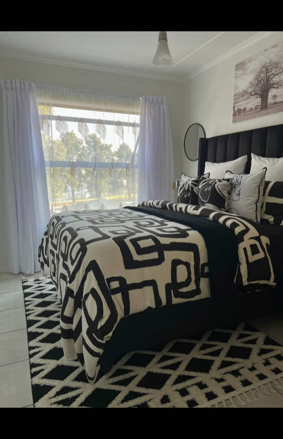 Monochrome makeover in full effect ✨🖤🤍 New curtains, new vibe—watch to see the transformation!. White curtains, bedding, black throw, character cushions & wall art: @Sheet Street . Bedroom & lounge rugs: @Ahmed Carpets &Persian Rugs. Bedroom mirrors: @PEP Home. Pedastals & headboard: Thabie luxury furniture. L Couch : Depedro Designs. Tv stand, bubble couch, coffee table, standing lamp. Standing mirror, side lamps: @decofurn. Faux plant: @BuildersSA  #transformation #Bedroom #bedroommakeover #Monochrome #BlackAndWhite #bedroominspo #decortok #HomeStyle #Fyp #apartmentliving #creatorsearchinsights #viralvideos #trendingvideo #InteriorDesign #hometiktok 