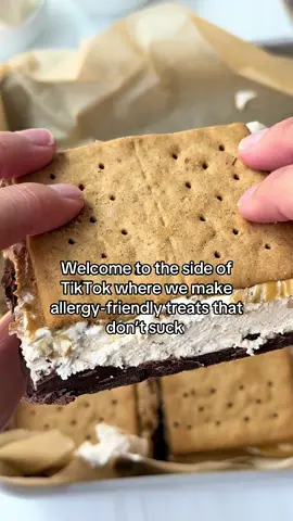 These no-bake protein s’mores are the perfect allergy-friendly treat to make when it’s too hot to turn the oven on! S’mores are such a nostalgic treat and this viral twist on the classic recipe uses only 5 ingredients! I leveled up this recipe by adding a layer of creamy @Sunbutter and it made this treat extra delicious!  PROTEIN FROZEN S’MORES 1 package gluten free graham crackers 1 package dairy free mini chocolate chips 1 ½ tbsp vanilla protein powder 1 container coconut whipped cream  ½ cup sunflower seed butter INSTRUCTIONS Gather your ingredients. Add a layer of graham crackers to the bottom of your baking pan. Melt chocolate chips. Drizzle over layer of graham crackers. Combine whipped cream and protein powder and spread over chocolate layer. Drizzle on sunflower seed butter. Add graham crackers on top. Freeze until hardened. Slice into squares and enjoy! #glutenfreerecipes #glutenfreefood #glutenfreedairyfree #dairyfreelife #summerdessert #proteindessert
