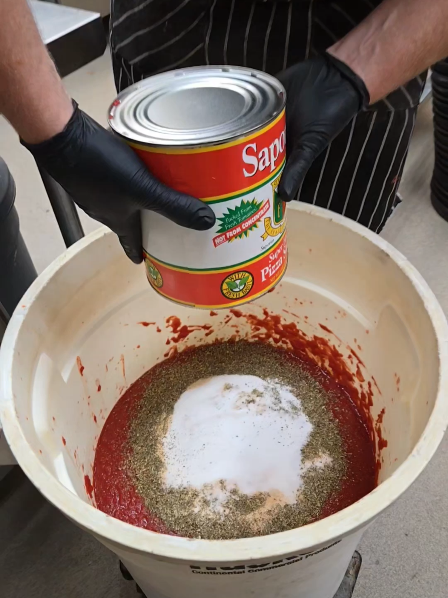 Person is emptying cans tomato sauce into a bucket #BVIRAL @ploppinsauce