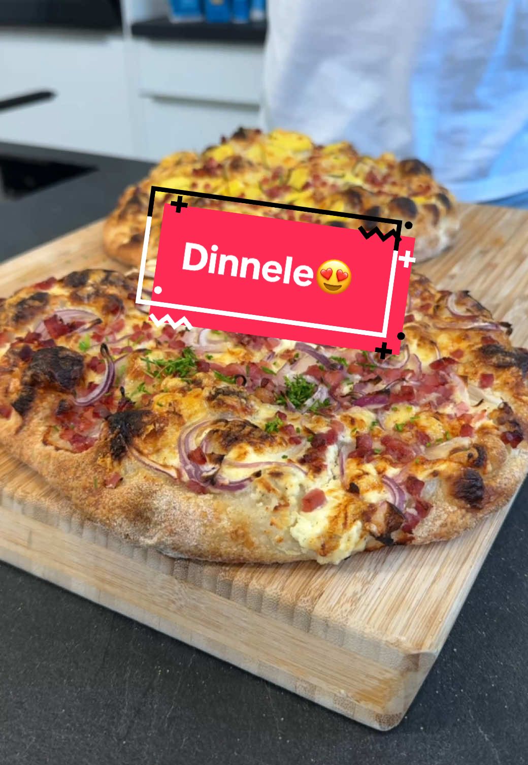 Schwäbische Dinnele.😍 Zum Rezept geht es hier.👇🏼 Für drei Dinnele benötigst du: •550g Weizenmehl Type 00 (z.B. „Teichners‘ Beste“ •360g kaltes Wasser •15g Salz •15g Olivenöl •5g Frische Hefe  Außerdem: •250g Speck •3 rote Zwiebeln •3-4 gekochte Drillinge •Rosmarin Für die Schmandsauce: •400g Schmand •1/2 Zitrone 1️⃣Teig zubereiten: Mehl, Wasser, Hefe, Salz & Olivenöl in eine Schüssel geben und ca. 12 Min. kneten – per Hand oder Maschine. Der Teig soll schön geschmeidig sein. Teig auf die Arbeitsfläche klatschen, dehnen, falten, rund schleifen (Slap nicht vergessen 💥) und 15 Min. abgedeckt entspannen lassen. 2️⃣Teilen & Formen: Den Teig in 3 gleich große Stücke teilen. Von außen nach innen falten, umdrehen und auf Spannung schleifen. Dann luftdicht verschließen und über Nacht im Kühlschrank reifen lassen. Am nächsten Tag: 4️⃣Creme für die Base: Schmand mit Salz, Pfeffer, Muskat & Zitronensaft verrühren. Rote Zwiebeln in feine Ringe schneiden, gekochte Kartoffeln in Scheiben, Bergkäse reiben. 5️⃣Teig bearbeiten: Teigling mit Selbstbewusstsein abstechen, aufs Semolabett legen und mit den Fingerkuppen zuerst außen, dann innen massieren. Semola zur Seite schieben. Anschließend mit euren Toppings belegen. Backen: 6️⃣Ab auf die Schaufel und bei 250 °C Ober-/Unterhitze ca. 15 Minuten backen. Mit frischem Schnittlauch toppen, in Stücke schneiden und einfach genießen. Habt ihr Fragen? Haut raus.👇🏼