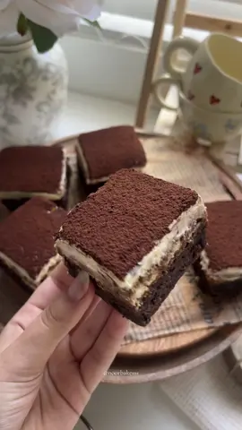 Honestly better than classic brownies!🤎 Recipe below👇🏼 Ingredients:  Brownie Base - 180g caster sugar -  2 eggs -  113g browned unsalted butter -  170g chopped chocolate -  80g plain flour -  3 tbsp cocoa powder -  1/2 tsp salt  ☕️ Middle Layer (Ladyfingers + Coffee) -  Around 16 ladyfinger biscuits  -  150ml strong brewed coffee, cooled 🤍 Mascarpone Cream Topping -  225ml double cream -  225ml mascarpone -  65g sugar 🍫 Decoration -  Unsweetened cocoa powder (for dusting) Method:  1. Preheat your oven to 170°C.  2. Brown the butter in a pan, then melt the chocolate separately. Stir them together and let the mixture cool slightly. 3. In a large bowl, whisk the eggs and caster sugar until pale and fluffy. 4. Add the chocolate and butter mixture to the eggs and sugar, whisk to combine. 5. Sift in the flour, cocoa powder and salt, then fold until just incorporated. 6. Pour the batter into a lined square tin and spread evenly. 7. Bake for 22 minutes. Let it cool completely in the tin. 8. Brew about 150ml of strong coffee and allow it to cool. 9. Briefly dip each ladyfinger into the coffee, then arrange them tightly in a single layer over the cooled brownie base. 10. In a bowl, whip the double cream to soft peaks. 11. Add the sugar and mascarpone, then beat until the mixture is thick and smooth. 12. Spread the mascarpone cream evenly over the ladyfinger layer. 13. Cover the tin with foil or cling film and refrigerate overnight (at least 8 hours). 14. Just before serving, dust the top with unsweetened cocoa powder. Enjoy! 🤎 #baking #brownies #tiramisu #explore #baketok #tiramisubrownies #dessert #aesthetic #sweettreat #trending #recpie #easyrecpie #fyp #asmr #brownielovers #bakingtherapy 
