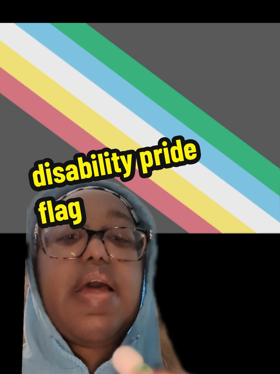Please use the inclusive disability pride flag. VD: A charcoal grey flag bisected diagonally from the top left corner to the lower right corner by five parallel stripes in red, pale gold, pale grey, light blue, and green.  Sicilyjoy is a Black enby wearing glasses and a blue hoodie. #greenscreen #disabiltypridemonth 