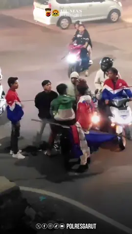 Belasan Anggota Geng Motor Diamankan, 1 Pelaku Pengeroyokan Di Tahan, 2 Lainnya DPO Garut | Aksi kekerasan yang di lakukan oleh kelompok pemuda yang menamakan diri sebagai kelompok Moonraker Kadungora akhirnya berujung pada pembubaran oleh pihak Kepolisian. Rabu malam (25/06/2025). Setelah video aksi kekerasan yang berdurasi 36 detik viral di berbagai platform media sosial pada hari Sabtu, 21 Juni 2025 yang berlokasi di Simpang Empat Nangkaleah tepatnya Kampung Nangkaleah Desa Leles Kabupaten Garut. Motif dari kejadian ini, bermula ketika keempat korban yang merupakan anggota Moonraker, tidak menghadiri acara Anniversary Moonraker. Ketika korban melintas di Simpang Empat, ke empat korban di hampiri oleh anggota moonraker Garut Utara. Setelah itu ke empat korban di berhentikan oleh anggota Moonraker Kadungora dan salah satu pelaku berkata kepada korban “Kamana saria teu daratang ka acara anniversary” (kemana kalian tidak datang ke acara anniversary). Tidak lama kemudian datang beberapa temannya yang langsung melakukan pengeroyokan terhadap korban. Polres Garut langsung bergerak cepat melakukan penyelidikan dan penangkapan. Unit III Pidum Satreskrim Polres Garut bersama Polsek Leles berhasil mengamankan belasan anggota moonraker yang berada di lokasi kejadian. Dari belasan anggota geng motor tersebut ada tiga orang yang merupakan pelaku utama dan terlibat dalam dugaan tindak pidana pengeroyokan. Dalam proses tersebut, polisi juga menyita sejumlah atribut khas kelompok Moonreker seperti bendera, jaket, dan baju yang menjadi simbol eksistensi kelompok tersebut. Yang lebih memprihatinkan, mayoritas anggota Genk Monreker Kadungora rata-rata berasal dari kalangan pelajar. Wakapolres Garut Kompol Bayu Tri Nugraha menegaskan bahwa keberadaan geng motor atau kelompok serupa yang meresahkan masyarakat tidak akan diberi ruang di wilayah hukum Garut. “Kami tidak akan mentolerir segala bentuk kekerasan dan tindakan kriminal yang di lakukan oleh kelompok mana pun, Geng Moonraker Kadungora secara resmi kami bubarkan dan untuk 3 pelaku pengeroyokan akan kami proses sesuai dengan ketentuan hukum yang berlaku,” tegasnya.