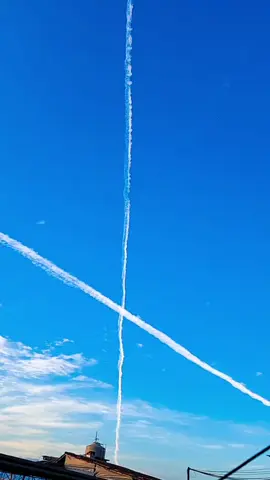 Avião fazendo trilhas de fumaça no céu.  Teoria da conspiração dizem que estão fazendo controle populacional, outras que estão manipulando o Clima. mas a verdade é que ninguém sabe a razão de gastar fulortunas para fazer trilhas no céu. 