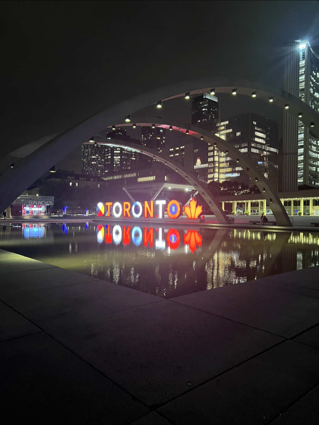 Nathan Phillips Square glowing under the city lights ,Toronto’s heartbeat after dark. ✨🏙️ #NathanPhillipsSquare #TorontoAtNight #TorontoCityLights #DowntownToronto #CanadaNights #UrbanVibes #Cityscape #NightPhotography #TorontoViews #TravelToronto