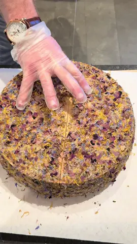 This one is one of favorite! Alp Blossom! 🌸🧀 Now made in Germany at Hofkäserei Kraus - Alp Blossom pays tribute to the Alpine environment that helps shape and flavor the milk used in production. This cheese is coated in a diverse combination of dried flower petals, herbs, and spices that grow out in the pastures surrounding the dairy.  Utilizing raw//unskimmed milk, the already present floral and herbaceous notes of the cheese are further drawn out by the addition the rind.  Not just photogenic and beautiful, Alp Blossom has deep flavors and prominently stands out on any cheeseboard. 😍 #cheeseshop #cheeselover #foodoftiktok #cheeseboard #greenvillesc #yeahthatgreenville #gvltoday #greenville360 