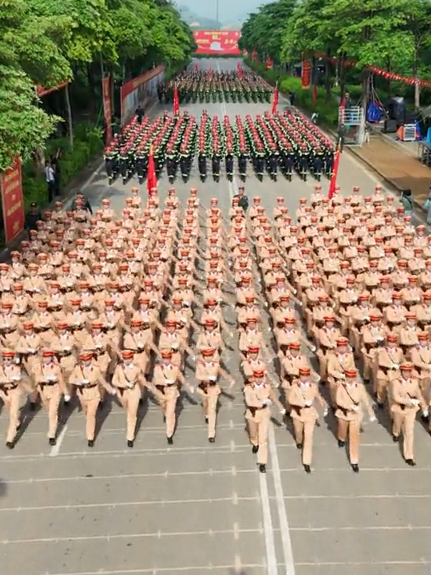 P2 : Khoảnh Khắc Hùng Dũng Từ Trên Cao Tại Khu Hợp Luyện A80 - Từ trên cao nhìn xuống, một bức tranh uy nghiêm và đầy sức mạnh hiện ra trên sân tập của Khu Hợp Luyện A80. Đó là khoảnh khắc hàng nghìn cán bộ, chiến sĩ Công an nhân dân xếp thành từng khối vuông vức, di chuyển nhịp nhàng như một dòng chảy thép, tạo nên một hình ảnh vô cùng ấn tượng. Khoảnh khắc này không chỉ là một bức ảnh, mà là minh chứng rõ nét cho sự kỷ luật, tinh thần thép và ý chí quyết tâm của toàn lực lượng. Sự di chuyển đồng bộ, tiếng bước chân dứt khoát và đều đặn tạo ra một âm thanh vang vọng, mạnh mẽ. Mỗi khối quân đều là một chỉnh thể hoàn hảo, thể hiện sự rèn luyện nghiêm túc và sự đồng lòng tuyệt đối. Dù là khối cảnh sát cơ động, cảnh sát hình sự, hay các đơn vị khác, tất cả đều hòa chung vào một nhịp điệu, tiến về phía trước với sự tự tin và oai nghiêm. - Trong bức tranh toàn cảnh ấy, nổi bật hơn cả là khối Nữ Cảnh Sát Đặc Nhiệm. Đây không chỉ là một đơn vị, mà là biểu tượng của sự mạnh mẽ, bản lĩnh phi thường. Khoác lên mình bộ trang phục tác chiến màu đen, với những trang bị chuyên dụng, các nữ chiến sĩ di chuyển dứt khoát, ánh mắt kiên định. Họ là những 