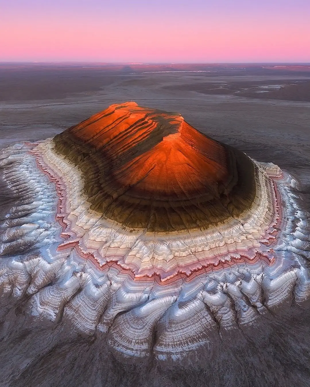The Bokty Mountain, located in the Mangystau region of western Kazakhstan is described as “cake-shaped” due to its striking horizontal strata of rock in varying colors. This geological formation is part of the Ustyurt Plateau and stands out because of its unique appearance that resembles a stacked cake or a tiered dessert. The vivid bands come from different sedimentary layers that have been exposed over time by erosion. Though not very tall, Bokty is a popular destination for photographers and geologists due to its surreal, otherworldly look. It’s part of a larger region filled with unusual landforms and colorful rock formations, making it a hidden gem of Kazakhstan’s natural wonders. all photos by Daniel Kordan