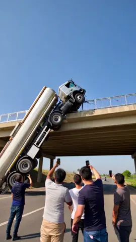 A fuel tanker was left hanging in a bizarre position after an accident on the bridge. It looks extremely dangerous, but luckily, there was no explosion. That was pure luck — a little more, and things could have gone terribly wrong. #crash #crashed #damage #ai #news #collapse #car #cars #bridge #danger #fuel #tanker #wow #fail #what #911