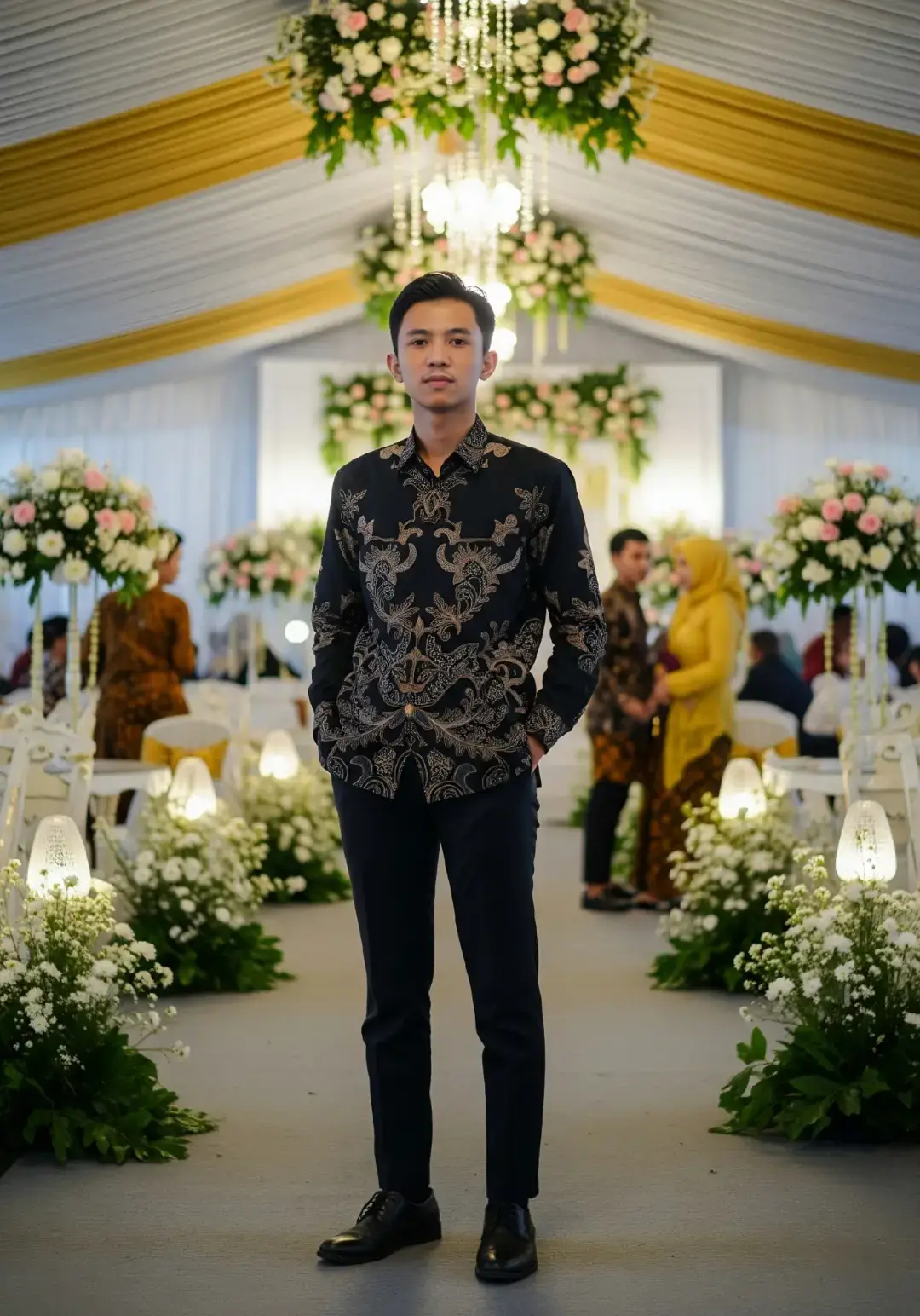 prompt ⬇️ . . . Buatkan Seorang pria muda usia 18 tahun khas Indonesia, berpenampilan rapi dan percaya diri, berdiri santai dengan satu tangan di saku dan satu tangan memegang ujung baju batik hitam bermotif elegan. Ia mengenakan celana bahan gelap dan sepatu kulit formal hitam. Rambut hitam sedikit menggelombang dengan model comma ala korea. Latar belakang adalah suasana kondangan khas Indonesia, dengan dekorasi tenda berwarna putih dan emas, hiasan bunga segar, lampu gantung, serta tamu-tamu lain yang mengenakan batik dan kebaya terlihat samar di belakang. Pencahayaan hangat dan suasana meriah namun elegan, menambah kesan acara pernikahan tradisional namun modern. Gaya visual: Fotorealistik, cerah dan bersih, detail tajam Rasio: 3:4 Pose: Berdiri santai, menatap kamera #foryoupage #trending #lewatberanda #ai #prompt #chatgpt #fypシ゚viral #fy #fyp 