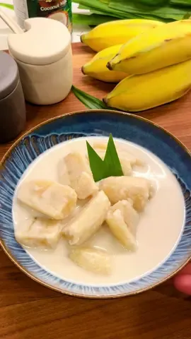 Thai Banana in Coconut Milk (Gluay Buat Chi) One of my all-time favorite Thai desserts—and my kids love it too! 💛 It’s super easy to make with just a few simple ingredients. I like to use ripe but still firm Thai bananas so they hold their shape and don’t get mushy when cooked. In this recipe, there’s no need to boil the bananas with the skin on first—just peel and cook them directly in the coconut milk. Ingredients: 🍌 10 Thai bananas (firm but ripe) 🥥 500 ml coconut milk 🍯 70 g coconut sugar 🧂 1/4 tsp salt 🌿 3 pandan leaves (optional) Instructions: 1. Mix 1 tsp of salt with water in a bowl and set aside. 2. Peel the bananas, cut each into 4 pieces, and soak them in the salted water for 5–10 minutes. This helps remove sticky sap and prevents browning. 3. In a pot, heat 250 ml of coconut milk with the coconut sugar, 1/4 tsp salt, and pandan leaves (if using) over medium-low heat. Stir until the sugar dissolves. 4. Rinse and drain the bananas, then add them to the pot. Pour in the remaining 250 ml of coconut milk. 5. Simmer gently for about 10–15 minutes, or until the bananas are tender. Be careful not to overcook—they can turn too soft. 6. Serve warm or chilled, and enjoy 🤍 #ThaiDessert #GluayBuatChi #BananaInCoconutMilk #EasyThaiRecipe #ammsthaikitchen 