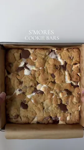 S’mores cookie bars Ingredients  1 1/4 (185g) cups all purpose flour  1/2 cup (115g) unsalted butter, melted and cooled 1 tbsp vanilla bean paste  1/2 cup(100g) light brown sugar  1/3 cup (67g) cup granulated sugar  1 large egg, room temp 1/2 tsp baking soda  Pinch of salt 1 1/2 cup semi sweet chocolate chips  1 1/2 cup mini marshmallows 8 sheets of graham crackers Method: Preheat the oven to 350 F.  Make dry batter: In a mixing bowl combine all purpose flour, baking soda and salt. Mix well and set aside. Make wet batter: In a separate bowl add melted butter along with light brown sugar and granulated sugar. Mix for 3 min until smooth paste forms . Crack in the egg and add vanilla beans paste, whisk for 2-3 min until the batter light in color.  Add the dry batter to the wet batter. Add in 1 cup of chocolate chips. Reserve the remaining for later use. Mix the cookie dough until just combined. Do not over mix the batter. Take a 9*9 baking dish line with parchment paper. Spread a layer of graham crackers on the base. Add half of the cookie batter on top spread it evenly. Add a layer of marshmallows on top. Top it with the remaining chocolate chips. Add the remaining cookie dough on top. Bake for 25-28 minutes or until the cookie marshmallows are melted and cookie dough is lightly golden from the top. Let it cool completely before cutting and enjoy. #smores #cookie #bars #cookiebars #Recipe 