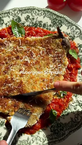 Auberginen Schnitzel 🍆 Dieses Auberginen Schnitzel gehört einfach in den Sommer, weil es sooo eine frische Abwechslung zu einem normalen Schnitzel ist! Schmeckt fantastisch und ist so einfach und schnell gemacht🥰👌🏻 Zutaten (2x Schnitzel): 2 Auberginen Wasser, Mehl und Panko-Mehl zum Panieren 1 Dose geschälte ganze Tomaten Olivenöl 1 Knoblauchzehe Salz, Pfeffer Mediterrane Gewürze optional Basilikum und Parmesan (Standard oder vegan) Zubereitung: Die Aubergine mit einer Gabel mehrmals einstechen und im Ofen bei 200 Grad je nach Größe ca. 15 min backen. Gleichzeitig die Tomaten in einen Topf mit etwas Olivenöl geben, zerdrücken und die Gewürze sowie Knoblauch hinzugeben. Ganz kurz köcheln lassen. Schale der leicht abgekühlten Aubergine entfernen und danach mit einer Gabel wie im Video gezeigt fingerdick platt drücken. Etwas Mehl mit Wasser und Gewürzen vermengen, die Aubergine darin wenden und in Panko-Mehl panieren. Mit etwas Olivenöl von beiden Seiten knusprig braten. Tomatensauce auf einem Teller verteilen, das Auberginen Schnitzel darüber legen und optional mit Parmesan und Basilikum bestreuen. Es ist einfach sowas von lecker! Guten Appetit 😋 #sommerrezepte #aubergine #schnitzel #einfacherezepte #schnellesrezept #gesunderezepte #vegan #vegetarisch #gemüse 