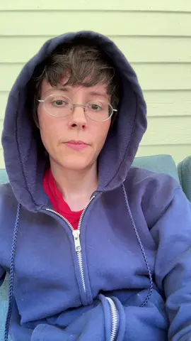 Art chat. Video description: I am sitting outside and talking to the camera. I am a middle aged white woman with short brown hair and glasses. I have dark eyes and I am wearing navy blue hoodie with the hood up #art #artist #disabledartist #nothanks #no 