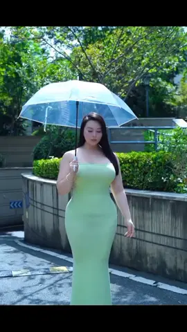 gadis berpayung jalan di taman sambil menikmati alam di sekitarnya..