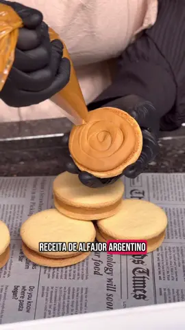 Na feira da Mara Cakes esse ano recebi uma caixinha com alfajor de uma aluna querida, que me contou que com essa receita ganhou uma batedeira em um curso, eu não sei se vc vai ganhar um concurso com ela também, mas sem dúvidas o coração dos clientes você vai 😂 3° receita do 7 dias 7 receitas do meu livro digital ❤️ Ingredientes:  7 gemas 190g de açúcar refinado 240g de farinha de trigo 240g de amido de milho 200g de manteiga sem sal em ponto de pomada 5g de essência de baunilha 6g de fermento em pó Raspas de limão opcional  Preparo:  • Em uma vasilha misture o açúcar, o fermento em pó, a farinha de trigo, o amido e a manteiga, amassando com a ponta dos dedos até obter uma farofa. • Acrescente as gemas e a essência e amasse novamente até obter uma massa lisa e macia! • Envolva em papel-filme e leve para gelar de 15 a 30 minutos.  • Abra a massa entre duas folhas de papel manteiga com uma espessura de 5 mm, depois corte com cortadores redondos de 5 cm ou 10 cm de diâmetro. • Leve para gelar por 20 minutos  • Sobre papel manteiga e o fundo de uma forma, leve para assar em forno pré-aquecido a 180°C até que fiquem levemente dourados na parte de baixo.  • Deixe esfriar e recheie com doce de leite e banhe no chocolate #alfajor #alfajoargentino #receitadealfajor #receita #confeitaria 