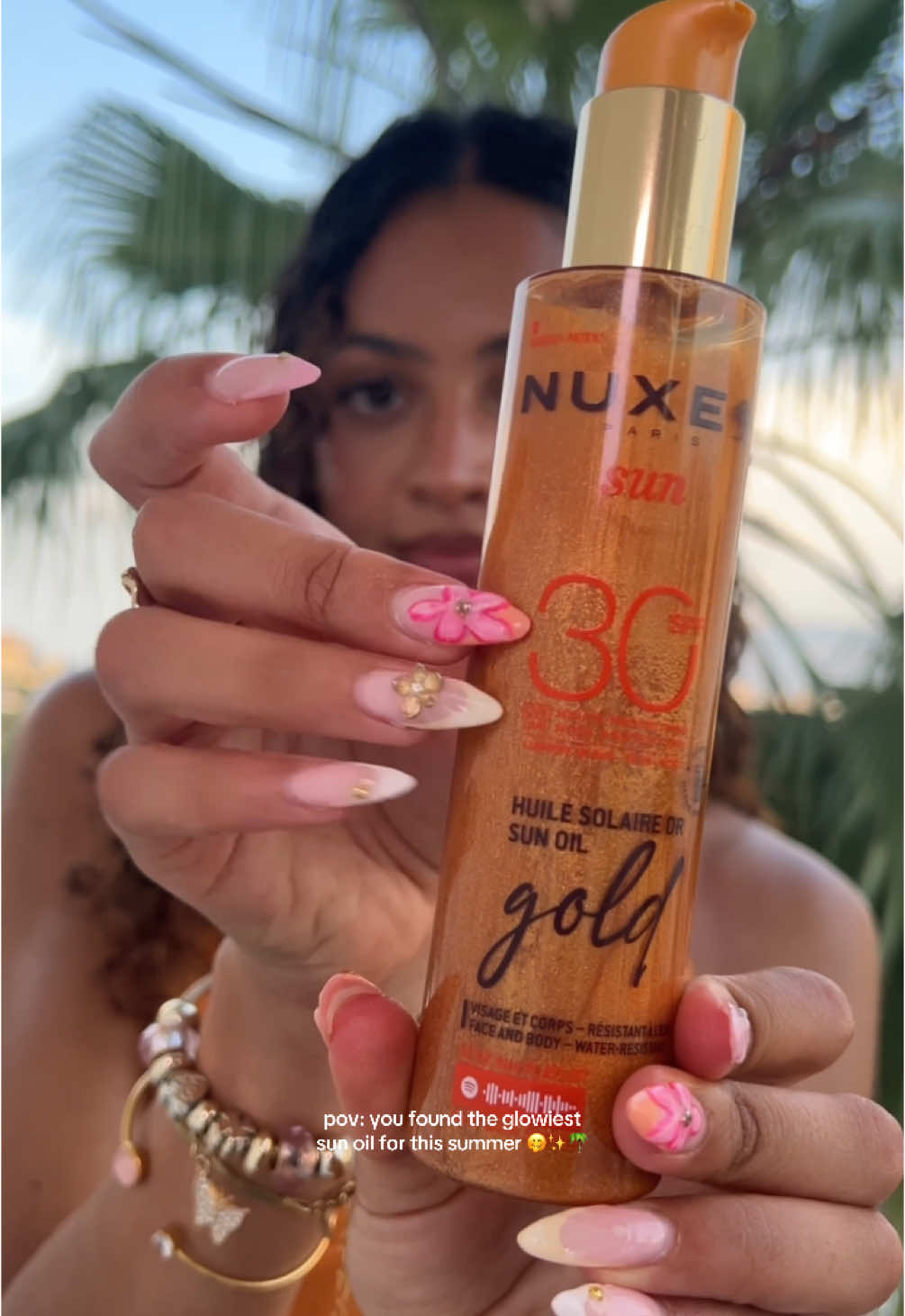 Golden hour now comes in a bottle 🌅 Our new Sun Oil Gold beautifies all skin tones with an incredible shimmery and gold finish ✨ With notes of Sweet Orange, Tiaré Flower and Vanilla, its scent is a real invitation to enjoy that summer feeling 🌴 Tag someone who needs to upgrade their SPF game 🌞 @lingeer__ 🧡 #Nuxe #NuxeSun #NuxeSunOil #SunOilGold #TanningSunOil #ProtectandGlow #SunProtection #Sunscreen #Suncream #SPF #SPF50 #Summer #Summer2025 #Skincare #Bodycare #Beauty #BeautyTok 