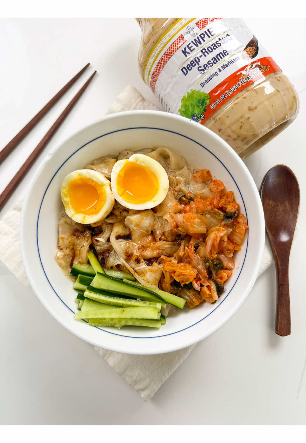 #ad DEEP-ROASTED SESAME RICE PAPER NOODLES Stop what you are doing because @Kewpieusa’s Deep-Roasted Sesame Dressing is available at Costco’s across the US! I’m a big fan of Kewpie’s mayo so I knew I had to buy it when I saw this dressing at Costco. I was hungry and feeling lazy so I whipped up this easy rice paper noodle dish by using Deep-Roasted Sesame Dressing then topping it with soft jammy eggs, cucumbers, and kimchi to make it a full satisfying meal. Get yours today at Costco and try this rice paper noodle dish yourself! How would you use this delicious dressing? Comment below! Recipe: 8 sheets rice paper (22cm) 1/3 cup Kewpie’s Deep-Roasted Sesame Dressing 2 soft-boiled eggs 1/2 cucumber, thinly sliced 1/4 cup kimchi, roughly chopped 2 tsp chili oil 1. Dip 2 pieces of rice paper (or 3 if you want thicker noodles) in lukewarm water quickly, shake off excess water, then stack together aligned evenly. Brush your cutting board with oil then place the rice paper on top. Once rice papers are rehydrated, about 30 seconds to 1 min, brush the top side of the stacked rice paper with some oil (to prevent from sticking later). Cut noodles into 1 inch thick noodles or your desired size. Transfer noodles to a bowl of cold water to keep it hydrated. Repeat with remaining rice paper. 2. Drain rice paper noodles completely then add to a bowl. Pour deep roasted sesame dressing then mix to coat noodles evenly. 3. Top with soft-boiled eggs, cucumbers, kimchi, and chili oil. Enjoy! #kewpie #ricepapernoodles #EasyRecipes