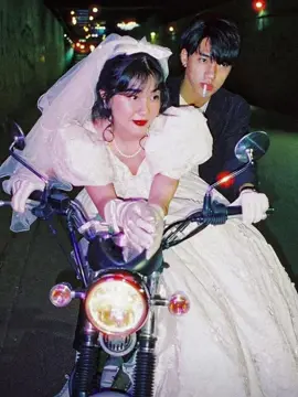 You’ve probably seen the photos couples lit by neon signs, eating noodles on the street, riding motorbikes through alleyways. That’s the “’80s Hong Kong pre-wedding” style that’s making a comeback. It’s inspired by films like Fallen Angels and Chungking Express, where the mood comes from color, grain, and quiet moments. It started as a way to break away from stiff, formal portraits showing something more real, more lived-in. Photographers like @kemmiethecat helped bring it back, especially in Vietnam, where it connects with how a lot of people’s parents took their wedding photos back then. For some couples, it’s nostalgic. For others, it just feels more honest. #fyp 
