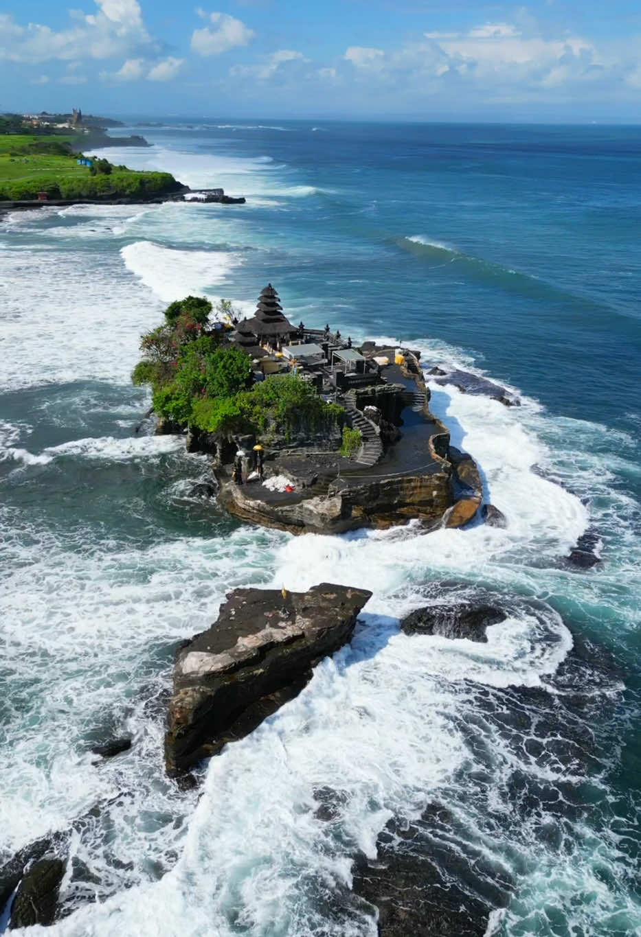Tanah Lot Temple is one of Bali’s most important landmarks, famed for its unique offshore setting and sunset backdrops. An ancient Hindu shrine perched on top of an outcrop amidst constantly crashing waves. This is a must visit place in Bali. Tanah Lot Magnificent Balinese Temple in the Open Ocean To many people, Tanah Lot epitomizes the romantic island of Bali. Tanah Lot means Land in The Sea, a perfectly fit name for its unique offshore settings. The silhouette of Pura Tanah Lot is one of the most popular iconic features of Bali. Imagine the image of a Balinese temple (pura) perched high on the rock, facing the wide open ocean. With the crashing waves below and the dramatic colors of the dusk sky as background, lit by the slowly disappearing sun. Tanah Lot is located in Tabanan, only around 30 km away from Denpasar. The temple is located some 300 meters offshore. The history of Tanah Lot temple was believed to date back to the 16th century, by Dang Hyang Nirartha, a respected religious figure in Bali. 🚨Save this post ,share, Like & comment   📸 @henryramirezj Tag someone you’d like to visit Tanah Lot Temple with! Follow for more!  @henryramirezj Location📍 Tanah Lot Temple   #tanahlot  #Baliindonesia #Balilife #Canggu #Ubud #Balitrip #Nusapenida #Balidaily #Baliisland #Balivibes #Nusapebidaisland #lBalitour #Diamondbeach #Uluwatu #Travelbali #viajeros  #viajando  #MelastiBeach #UngasanBali #baliismylife #Theedgebali #Savayabali #balangabeach #padangpadangbeach #cretyaubud #Kelingkingbeach #nusapenida #baliwaterfalls #Monkeyforest #Rockbar