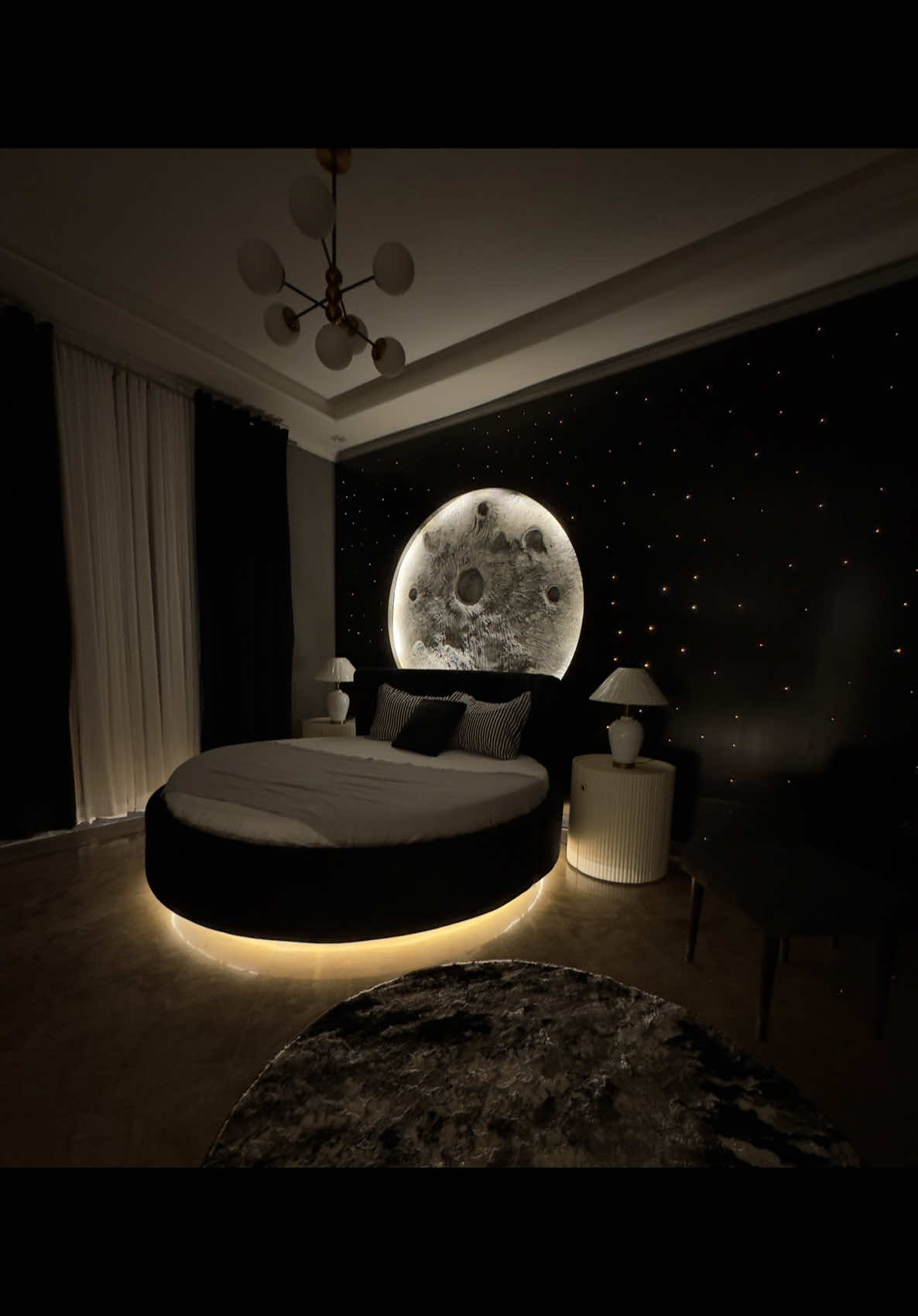 New interior styling project 🔔 When my client asked for a dark themed bedroom , I took it out of this world ✨🚀 I created a space inspired sanctuary where the moon and stars shine right above your bed 💫✨ My client is over the moon now ☺️ Alhamdulillah ♥️ What do you think about this room … Curtains @signaturebyfouziaarmani  Lamps @eyecatching.lamps  #bismahassam #moonroom #darktheme #interiorstyling #interior #homedecor #transformation #roundbed #interiorsdesign #spacedecor #luxuryinteriors #dreambedroom 
