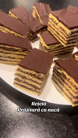 Prăjitură cu foi coapte și cremă fiartă cu cacao și nucă Foi (4 foi): 	☘️2 ouă 	☘️150 g zahăr 	☘️100 g unt topit 	☘️2 linguri miere 	☘️1 linguriță bicarbonat de sodiu stins 	☘️1 praf de sare 	☘️450-500 g făină (cât cuprinde) 	☘️esență de rom sau vanilie Mod de lucru: 	1☘️Amesteci ouăle cu zahărul, untul topit, mierea și bicarbonatul. 	2☘️Adaugi făina treptat până ai un aluat moale, nelipicios, care se poate întinde. 	3☘️Împarți în 4 bile, întinzi foi subțiri și le coci pe fundul tăvii la 180°C, 8-10 min. Cremă fiartă cu cacao și nucă: 	☘️500 ml lapte 	☘️150 g zahăr 	☘️3 linguri griș 	☘️2 linguri cacao 	☘️200 g unt (82%)          ☘️100 g ciocolata  	150 g nucă măcinată 	☘️esență de rom Mod de lucru: 	1☘️Fierbi laptele cu zahărul. Când dă în clocot, adaugi în ploaie grișul și cacao, amestecând continuu. 	2☘️Când se îngroașă, adaugi nuca măcinată, mai fierbi 2-3 minute, apoi lași la răcit. 	3☘️Încorporezi ,ciocolata untul moale, puțin câte puțin, și aroma de rom. Asamblare: 	☘️Pui crema între foi, acoperi cu ceva greu, și o lași la rece peste noapte. 	☘️Se poate pudra cu zahăr sau glazura cu ciocolată         ☘️Am întins 4 foi subțiri și din resturi ce am îndreptat am mai întins o foaie #cecilia #fallowme👈 