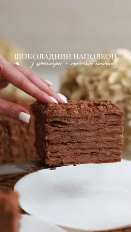 ✨ Шоколадный Наполеон с шоколадно-ореховым кремом - домашний, простой, без сложных техник 😍 Ваш безумный отклик на классические слоеные Наполеоны меня поразил! Но тот рецепт оставлю немного погодя 😉 А пока делюсь не менее вкусным шоколадным вариантом 🍫 🌰  ТІСТО тесто (на 8 лепешек, 18×18 см)  * Мука-370 г  * Какао (темное, алкализированное) - 22 г  * Соль-0,5 ч. л.  * Холодное сливочное масло 82% — 250 г  * Яйцо — 50 г  * Холодная вода-120 мл  * Уксус 9% — 10 г  * 10-15 г муки (если тесто липкое) Гот готовим:  1. смешай сухие ингредиенты.  2.Добавь натертое холодное масло — перетри до крошки.  3.в отдельной миске смешай яйцо, воду и уксус.  4.объедините все в мягкое тесто.  5. заверни и охлади 1+ ч в холодильнике.  6. раздели на 8 частей, раскатай.  7. выпекай каждый корж при 200-210°c ~6-8 мин. Обрезай корж пока горячий! (обрезки с лепешек на обсыпку). КРЕМ КРЕМ НУАР (шоколадно-ореховый) 150 г крема на слой, остатки крема на верх и бока.  * Молоко — 525 мл  * Сливки 30-33% — 150 мл  * Желтки-90 г  * Крахмал-38 г  * Сахар — 135 г  * Шоколад черный 70% — 180 г  * Фундучная паста натуральная или можно NUTELLA-100 г  * Сливочное масло 82% — 150 г   👩 🍳 Как готовить:  1.желтки, сахар, крахмал + молоко и сливки — смешать.  2.сварить крем до загустения.  3.добавить шоколад — размешать до однородности.  4. добавьте пасту.  5. Когда крем остынет до ~35-40°C-взбей сливочное масло и добавляй крем по 1 ложке  - Собирай торт сразу. Можно подавать на следующий день — тогда он идеально пропитается 🤎