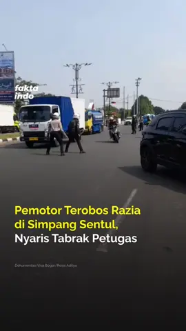 Pengendara motor nekat menerobos razia petugas di kawasan lampu merah Kandang Roda, Simpang Sentul, Sukaraja, Bogor, Jawa Barat, pada Senin (28/7).  Dalam aksinya, pemotor tersebut nyaris menabrak petugas yang mencoba memberhentikannya. Mereka tetap melaju kencang dan mengabaikan peringatan demi menghindari pemeriksaan.