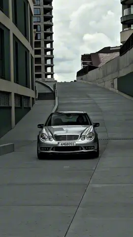 Mercedes-Benz E55 AMG - это высокопроизводительная версия E-класса, выпускавшаяся в двух поколениях: W210 (1997-2002) и W211 (2002-2006). Модель W210 была представлена в 1997 году как замена E50 AMG и получила 5.4-литровый V8 двигатель, разработанный AMG. В 2002 году на смену ей пришел E55 AMG в кузове W211, оснащенный компрессорным двигателем и пневматической подвеской AIRMATIC DC.  История Mercedes-Benz E55 AMG: W210 (1997-2002): Представлен как замена модели E50 AMG.  Оснащен 5.4-литровым V8 двигателем, разработанным AMG, мощностью 349 л.с.  Производился в кузовах седан и универсал.  Имел задний или полный привод.  W211 (2002-2006): Представлен в 2002 году, предлагался в кузовах седан и универсал.  Оснащен компрессорным 5.4-литровым V8 двигателем AMG, развивающим 476 л.с. и 700 Нм крутящего момента.  Получил пневматическую подвеску AIRMATIC DC.  Отличался спортивным дизайном AMG.  Производился до середины 2006 года, когда его сменил E63 AMG.  E55 AMG был известен своей мощностью, динамикой и комфортом, сочетая в себе спортивные характеристики с роскошью E-класса. 