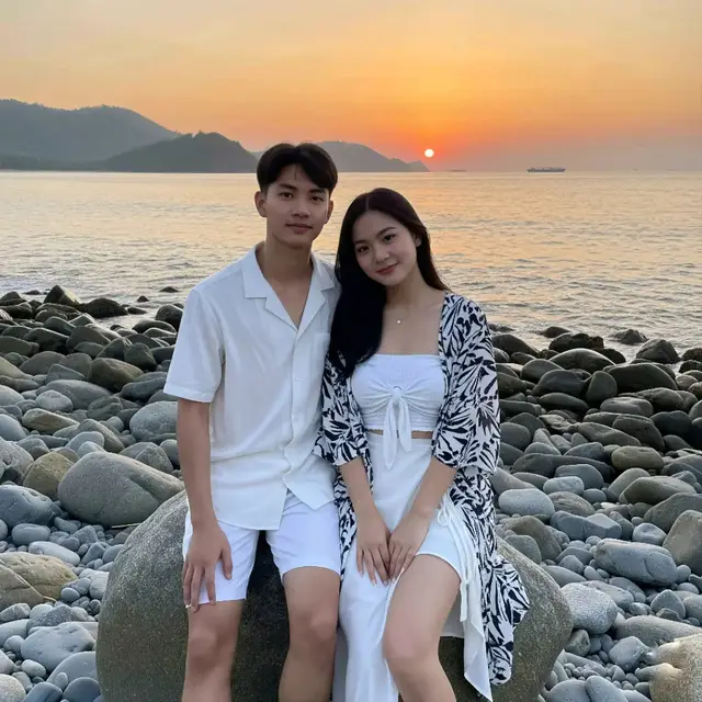 🫰🏻🫰🏻🫰🏻 my honey 🤍@zee asadel 🤍 prompt:👇🏻👇🏻👇🏻👇🏻 Foto amatir luar ruangan (kualitas rendah). Menunjukkan pasangan muda bersantai di atas batu besar di pantai berbatu di indonesia pada sore hari. (Subjek pria): Pria muda yang sangat Sunda, berusia 18-an, dengan wajah oval , tinggi 165 cm, tubuh ramping, lengan dan kaki agak kurus Rambut hitam model koma, kulit putih dan cerah, dengan kulit agak kasar sehingga pori-pori masih terlihat. Ia mengenakan kemeja putih polos lengan pendek dengan kerah berlekuk. Kemeja tersebut tampak terbuat dari bahan yang ringan dan bertekstur, seperti katun atau linen. Kemeja tersebut tidak dikancingkan, memberikan kesan santai. Celana pendek putih senada dengan atasannya. Celananya berpotongan longgar dan kasual. Tanpa alas kaki. (Subjek perempuan): Seorang perempuan muda yang sangat cantik berdarah campuran Korea dan Sunda, berusia 18-an, dengan bentuk wajah oval, dengan alis hitam alami, tinggi badan 163 cm, bertubuh ideal, dengan perut dan pinggang ramping, ukuran payudara sedang, kulit putih dan cerah. dengan kulit mengkilap berkilau, dan agak kasar sehingga pori-pori masih terlihat. Ia mengenakan atasan Tube putih polos. Bagian depan memiliki detail lipit atau simpul (twist) yang menjadi fokus utama. Sebagai lapisan luar, ia mengenakan outer kimono bermotif abstrak berwarna hitam dan putih. Dipadukan dengan rok lilit asimetris berwarna putih, dan Tidak memakai sepatu. Latar depan: Batu-batu pantai basah besar dan kecil, berwarna abu-abu dan cokelat, menutupi seluruh area yang paling dekat dengan subjek. Latar tengah: Kedua subjek menjadi fokus utama, mereka duduk di salah satu batu besar. Berdekatan sambil tersenyum hangat ke arah kamera, pose ini menangkap momen kebersamaan dan keceriaan di antara mereka. Laut tampak tenang dengan ombak-ombak kecil memecah di kejauhan. Beberapa perahu nelayan terlihat di cakrawala. Latar belakang: Perairan laut yang luas, bertemu dengan garis pantai yang dikelilingi perbukitan hijau yang rimbun. Matahari terbenam yang besar dan cerah terlihat di cakrawala. Langit berwarna jingga keemasan, dan di kejauhan tampak siluet kapal di laut. Pencahayaannya adalah cahaya alami dari matahari terbenam (golden hour). Cahaya ini menciptakan efek hangat, lembut, dan romantis. Subjek diterangi dari depan dan samping, sehingga bayangannya tidak terlalu keras. Matahari terbenam menjadi sumber cahaya utama dan fokus visual di latar belakang.  #ai #foryou #aiphoto #xybca #aiphotography #zee #photography #gemini #foryoupage #zeejkt48🦖 #4u #beach #aesthetic #chatgpt #faceswap #edit #edits #editphoto #prompterchallenge #prompt #for #memberjkt48 #jkt48 #zeenunew #zeejkt48♡ #couplegoals #couple #date #masukberanda #post 