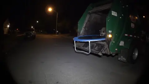 A crazy raccoon throws a trampoline out of the back of a trash truck and starts jumping on it #trampoline #funnyanimals #trashp#racoon 