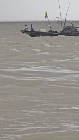 মা-ছেলে মিলে উত্তাল নদীতে ইলিশ মাছ ধরছে। 