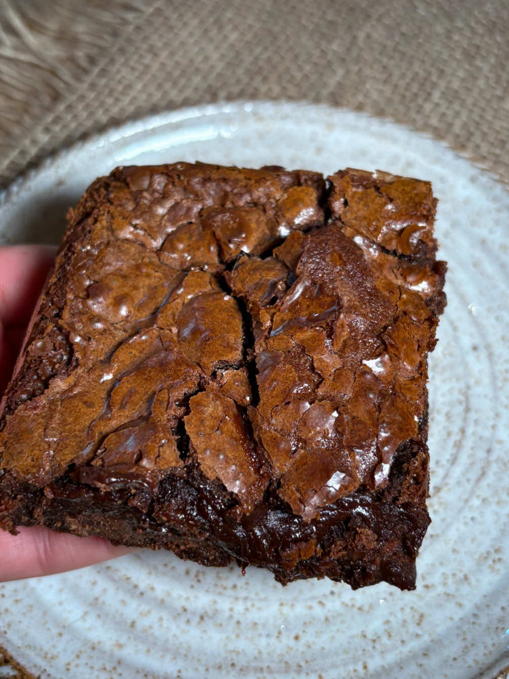 Receita de brownie da Paola Carosella: 🍫 Ingredientes: • 170 g de manteiga sem sal • 120 g de chocolate amargo (70%) • 200 g de açúcar branco refinado • 3 ovos em temperatura ambiente • 1 col. de chá de essência de baunilha • 40 g de cacau em pó • 60g de farinha de trigo • 1 col. de café de sal • 170 g de chips ou gotas de chocolate Opcional: Ela usa 1 col. de chá de café instantâneo pra realçar o sabor do chocolate, mas como não tinha fiz sem. Pode colocar castanhas, nozes, avelãs que fica maravilhoso também. Modo de preparo: Pré-aqueça o forno a 170-180 °C. Unte uma forma quadrada (20x20 cm) e forre com papel manteiga . Em uma panela, derreta a manteiga até adquirir cor de noisette (castanha) - esse processo realça o sabor. Desligue o fogo e misture o chocolate picado e o café instantâneo, até ficar homogêneo. Em outra tigela, bata os ovos com o açúcar por cerca de 8-10 minutos até a mistura clarear e o açúcar dissolver completamente - é fundamental para conseguir a casquinha crocante. Junte a mistura de manteiga e chocolate aos ovos, adicione a baunilha e misture. Peneire e incorpore os ingredientes secos: farinha, cacau e sal fino. Acrescente delicadamente os chips de chocolate, nozes e termine com o sal marinho por cima. Asse por 20 a 25 minutos — o interior deve ficar úmido, mas não líquido . Retire do forno e espere cerca de 2 horas antes de cortar (minha ansiedade não me deixou esperar, por isso no video parece mole, mas depois endurece) Toques finais: A manteiga noisette (deixar derreter até ficar dourada) confere um sabor mais profundo e amendoado. • Bater bastante os ovos + açúcar é o segredo da casquinha brilhante. • Usar forma de metal ajuda a casquinha assar primeiro, preservando a textura interna. #receita #brownie #masterchef #paolacarosella #receitasimples 