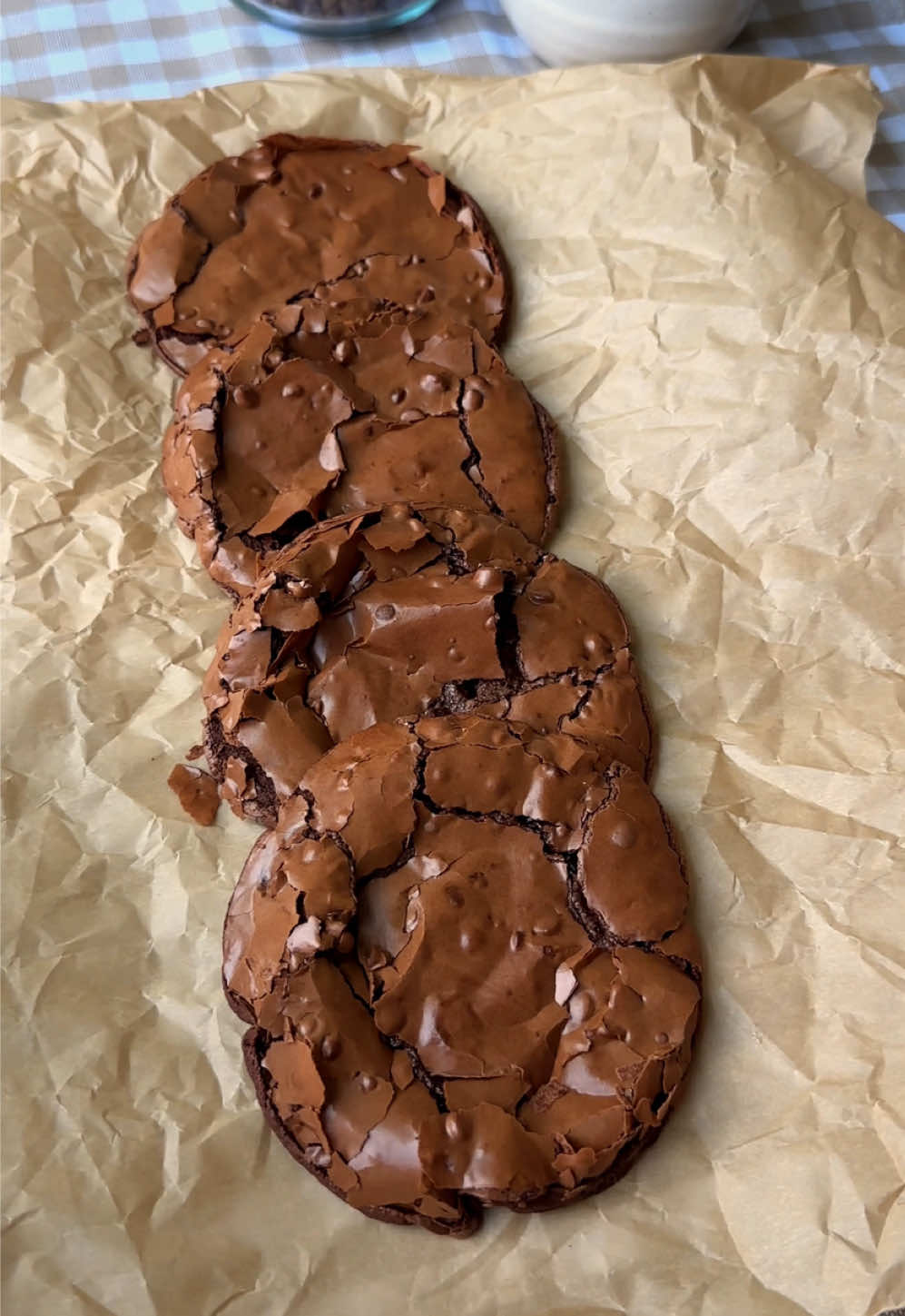 fudgey & chewy 🤤 if you prefer brownie corners & crinkly tops, you’ll absolutely love these!!  ingredients: 350g powdered sugar (a little less than 3 cups, but you can use 3 cups as well since this recipe is pretty forgiving) 60-65g cocoa powder (about 8-10 tablespoons if using tablespoons however using a scale is the best because tbsp weights may vary) – you can adjust this to 60g of cocoa powder if you prefer a sweeter cookie! 1/2 tsp salt 3 egg whites from 3 large eggs! (about 1/2 cup of liquid egg whites) 1/2 to 1 cup semi sweet chocolate chips (optional but recommended!) – depending how much chocolate you like! you can also use milk but i'm a semi sweet/dark choco girl. 1 tsp instant coffee (use 1/2 tsp if you are caffeine sensitive) 1 tsp vanilla bean paste (optional but adds great flavor) **if you live in a hot climate and the dough is super runny, try putting it in the fridge for 30 mins to an hour before baking**  directions: preheat oven to 350°f (175°c). line a baking sheet with parchment paper and lightly butter it so the cookies do not stick. in a large bowl, add powdered sugar, cocoa powder, salt, egg whites, instant coffee, and vanilla bean paste. stir until a thick glossy batter forms. fold in the chocolate chips if you are using them. scoop 2 to 3 tablespoons of batter per cookie onto the prepared baking sheet. leave at least 4 to 5 inches between each cookie because they spread a lot while baking. four to a cookie sheet will definitely prevent them from touching, but you can fit six if you do not mind if they bake into each other a bit. place the cookie tray directly in the middle of your oven. bake for 8 to 10 minutes. at 8 minutes the cookies will cool into a very fudgy texture. the longer you bake them, the less fudgy they will be. ten minutes should be the maximum baking time. immediately after baking, use a round bowl to gently scoot and round out the cookies. this will help “fluff” up the edges, which can be a bit flat right out of the oven. remove the cookies from the baking sheet right after shaping so they do not continue cooking on the hot tray. transfer to a cooling rack and let them cool completely before eating. enjoy!!! tips: -for the fudgiest texture, stick closer to 8 minutes of baking time.  -bake in the middle of the oven to prevent burning. use good quality cocoa powder for a richer chocolate flavor.  -if you don’t like coffee, you can skip the instant coffee, but it really brings out the chocolate taste.  -make sure to leave plenty of space between cookies because they spread a lot. four to a cookie sheet will keep them from touching, six if you are fine with them touching a little.  -transfer the cookies off the baking sheet right away so they stay soft in the middle.  -immediately after baking, use a round bowl to gently scoot and round out the cookies. this helps “fluff” up the edges, which can be a bit flat straight from the oven. #brownie #cookies #flourless #baking #glutenfree