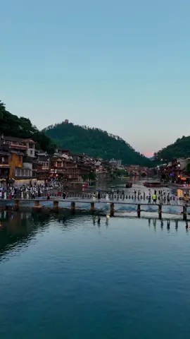Fenghuang Ancient Town ✨🏯 The charm of ancient architecture along the Tuojiang River 🌊🌉 Illuminated bridges, stone pathways, and wooden houses full of history 🪵🏮 Sunset moments here are unforgettable… colors and reflections that take your breath away 🌅💫 #Fenghuang #AncientTown #TuojiangRiver #travelasia #Beautiful 