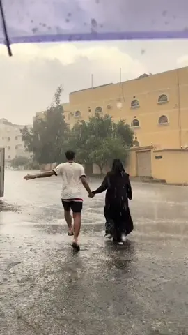 فرحة زوجين بالأجواء الماطرة في إحدى المناطق 