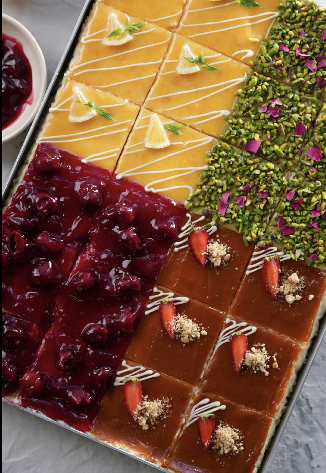 Tek seferde 4 farklı cheesecake hazırladık! 😍 Peki siz hangi dilimi tercih ederdiniz? Yorumlara yazın! 🍰💬✨ Kremamsı dokusu ve yumuşacık lezzetiyle Kaanlar Mascarpone, cheesecake’i bambaşka bir seviyeye taşıdı. 👌🏻😋 Siz de @KAANLAR ürünlerine online marketlerden kolaylıkla ulaşabilirsiniz. 🛒 #Kaanlar #işbirliği Tepside Cheesecake Malzemeler Tabanı için; 3 paket yulaflı bisküvi (393 g) 100 g Kaanlar Tereyağı Kreması için; 1000 g Kaanlar Mascarpone Peyniri 1,5 su bardağı şeker 400 ml krema 4 adet yumurta 2 yemek kaşığı un (26 g) 2 yemek kaşığı nişasta (22 g) 1 paket vanilya Vişne sos için; 1,5 su bardağı çekirdeksiz donuk vişne (170 g) Yarım su bardağı su (100 ml) 3 yemek kaşığı şeker 1 yemek kaşığı mısır nişastası Limon sos için; 2 adet yumurta sarısı 1 çay bardağı şeker 2 adet limonun suyu 2 adet limonun kabuğu 1 yemek kaşığı Kaanlar Tereyağı Fıstık sos için; Fıstık kreması Karamel sos için; Yarım su bardağı şeker 1 tatlı kaşığı Kaanlar Tereyağı 100 ml krema Süslemeler için; Limon dilimleri Taze nane Beyaz çikolata Çilek Bisküvi kırıntısı Kırık fıstık Gül yaprakları Hazırlanışı Tabanı için tereyağını tavada eritelim. Rondodan geçirdiğimiz yulaflı bisküvilerle karıştıralım. Tepsinin tabanına bastırarak yerleştirelim. Karıştırma kabına mascarpone ve şekeri alıp çırpalım. Kremayı da ekleyerek spatula ile karıştıralım. Un, nişasta ve vanilyayı ekleyip karıştırdıktan sonra teker teker yumurtaları ekleyelim ve güzelce yedirelim. Kremayı tepsiye aktararak önceden ısıtılmış fırında, 150 °C fansız ayarda 50 dk pişirelim. Sürenin sonunda fırını kapatalım ve kapağını yarım açarak 30 dk bekletelim. Oda sıcaklığına geldiğinde buzdolabına kaldırarak 1 gece dinlendirelim. Vişne sosu için tüm malzemeleri karıştırarak koyulaşana kadar pişirelim. Limon sosu için tereyağı hariç tüm malzemeleri karıştırarak pişirelim. Koyulaşınca ocaktan alıp tereyağını ekleyerek karıştıralım. Karamel sosu için tavaya aldığımız şekeri kısık ateşte karıştırmadan eritelim ve tereyağı ekleyerek karıştıralım. Krema da ekleyip tekrar karıştıralım. Soğuyan sosları ve fıstık kremasını cheesecake’in üzerine sürelim. Dilediğimiz şekilde süsleyip dilimleyerek servis edelim. Afiyet olsun!