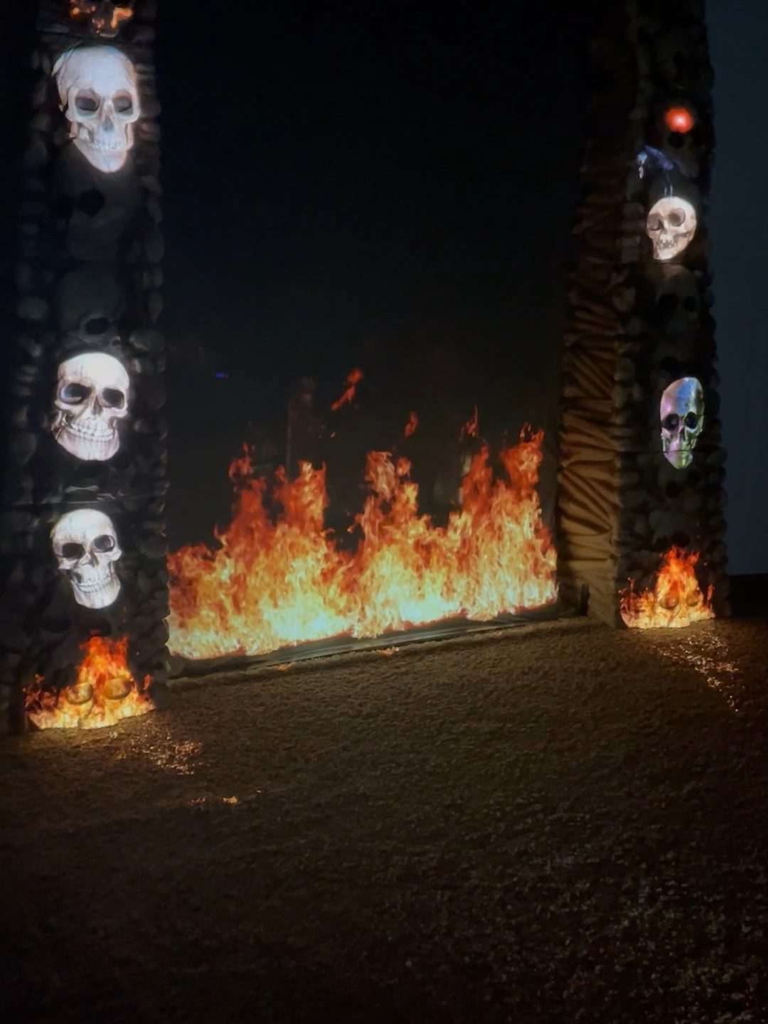 🔥💀 Our Skull Archway just got a new prisoner… a half-body skeleton chained in place, flames licking up from below. The lower half? Gone. The upper half? Screaming for mercy. Halloween just leveled up. #skeletonarchway #projectionmapping #HalloweenDecor #HauntedYard #skeleton #halloweendecorations