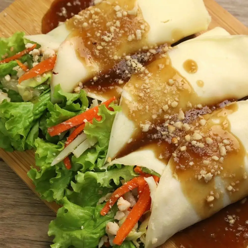 Ingredients ▢ 6 to 8 pieces Romaine lettuce ▢ 1/2 cup crushed peanuts ▢ 1/4 cup chopped parsley Fresh Lumpia Filling Ingredients ▢ 10 ounces extra firm tofu fried and cubed ▢ 1/2 cup small shrimp shell removed ▢ 1 piece Knorr Shrimp Cube ▢ 1/2 head cabbage chopped ▢ 3/4 cup green beans sliced crosswise ▢ 1 piece medium carrot julienne ▢ 1 cup sweet potato cubed ▢ 1 piece white onion chopped ▢ 2 cloves garlic minced ▢ 2 tablespoons fish sauce ▢ 1/2 cup water ▢ 1/8 teaspoon ground black pepper ▢ 3 tablespoons cooking oil Fresh Lumpia Wrapper Ingredients ▢ 1 cup all-purpose flour ▢ 2 pieces eggs ▢ 2 tablespoons canola oil ▢ 1 1/2 cups water ▢ 1/4 cup cooking oil or cooking oil spray Lumpia Sauce Ingredients ▢ 6 tablespoons brown sugar ▢ 1 1/2 tablespoons soy sauce ▢ 1 1/2 cups water ▢ 1 tablespoon garlic minced ▢ 1 tablespoon cornstarch Instructions Prepare the filling by heating oil in a pan or wok. 3 tablespoons cooking oil Saute onion and garlic until onion becomes soft and transparent. 1 piece white onion, 2 cloves garlic Add sweet potato. Stir. Pour water and let boil. 1 cup sweet potato, 1/2 cup water Add Knorr Shrimp Cube. Stir. Cover and continue to cook in medium heat for 5 minutes. 1 piece Knorr Shrimp Cube Remove the cover and let water evaporate. Add tofu and shrimp.Stir fry for 1 minute. 10 ounces extra firm tofu, 1/2 cup small shrimp Add cabbage,green beans, and carrot. Continue to stir fry for 3 minutes. 1/2 head cabbage, 3/4 cup green beans, 1 piece medium carrot Season with fish sauce and ground black pepper. Set aside. 2 tablespoons fish sauce, 1/8 teaspoon ground black pepper Meanwhile, make the fresh lumpia wrapper by beating the eggs in a large bowl. Pour oil and water. Whisk until all ingrediests are blended. 2 pieces eggs, 2 tablespoons canola oil, 1 1/2 cups water Slowly whisk-in flour into the mixture. Continue to whisk until all ingredients are well blended. 1 cup all-purpose flour Heat a non-stick pan. Lightly grease with oil or spray cooking oil. 1/4 cup cooking oil or cooking oil spray Scoop around 7 to 8 tablespoons of the lumpia wrapper mixture and pour into the pan. Swirl the pan to spread the mixture. Continue to cook in medium heat for 1 minute or until the wrapper is cooked. Note: the fresh lumpia wrapper is done when it gets unstuck from the pan. Remove the fresh lumpia wrapper from the pan. Arrange in a plate. Set aside. Note: perform this step until all the wrapper mixture are consumed. Prepare the Lumpiang Sariwa Sauce by boiling water in a sauce pan. Add soy sauce, brown sugar and garlic. Stir. 1 1/2 cups water, 6 tablespoons brown sugar, 1 1/2 tablespoons soy sauce, 1 tablespoon garlic Dilute cornstarch in 3 tablespoons water. Pour the mixture into the sauce pan. Stir and continue to cook until the sauce thickens. 1 tablespoon cornstarch Assemble the fresh lumpia (lumpiang sariwa) by laying a piece of wrapper flat on a large plate. Put a piece of lettuce leaf in the middle of the wrapper and top with the fresh lumpia filling and chopped parsley. Secure the filling by folding the lower part of the wrapper upwards until it reaches the filling, and then fold the sides inwards. Arrange each piece on a plate and top with lumpia sauce and sprinkle some crushed peanuts. 6 to 8 pieces Romaine lettuce, 1/4 cup chopped parsley, 1/2 cup crushed peanuts Serve. Share and enjoy!