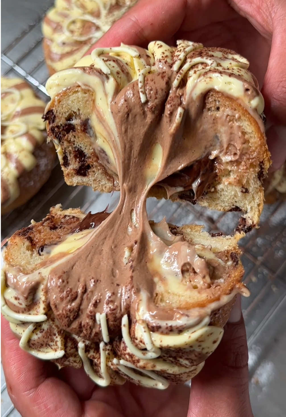 When should I pull out? #brioche #chocolate #vanilla  Chocolate chip brioche filled with chocolate hazelnut spread and chocolate vanilla ribbons. Recipe notes below.  Brioche: Ingredients 2 eggs 220g milk 185g unsalted butter, cubed and cold 10g dry yeast  500g plain flour  20g skim milk powder 6g salt  85g caster sugar 220g dark chocolate chips 200g Chocolate hazelnut spread Prepared vanilla & chocolate cream Icing sugar for dusting  Cacao powder for dusting Process:  Mix yeast with milk and skim milk powder and stir until combined. Add all other ingredients (except for chocolate chips) and mix on low, then high, for about 10-12 minutes. Proof will double in size. Add chocolate chips and portion to 120g while working quickly. Place into the desired backing dish and weight to create a centre hole. Back at C°180/356°F for 8-12 minutes. Allow to cool, then fill with spread and cream. Enjoy.  More recipe instructions and pro help see link in bio.