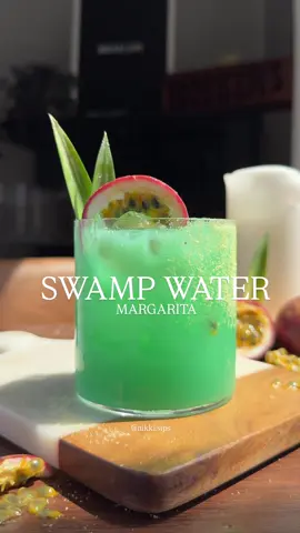 One of my most requested recipes from last summer (for good reason too). My swamp water margarita is filled with tropical flavors & fun, saying bye to summer never tasted so good ☀️ ——— Swamp Water Margarita You'll Need: 3/4 oz Blue Curaçao 1.5 oz tequila 1 oz passion fruit syrup 1 oz pineapple juice 12 oz Cream of Coconut 1 oz fresh squeezed lime juice Yuzu Citrus Salt agave 2 pineapple leaves 1 slice of passionfruit Brush your glass with agave and sprinkle citrus salt over top-set aside. In a shaker, combine blue curaçao, tequila, syrup, pineapple, cream of coconut, and lime. Shake with ice for 8 seconds. Strain into prepped glass with fresh ice and garnish with pineapple leaves & a passion fruit slice! #margarita #Summer #summercocktails 