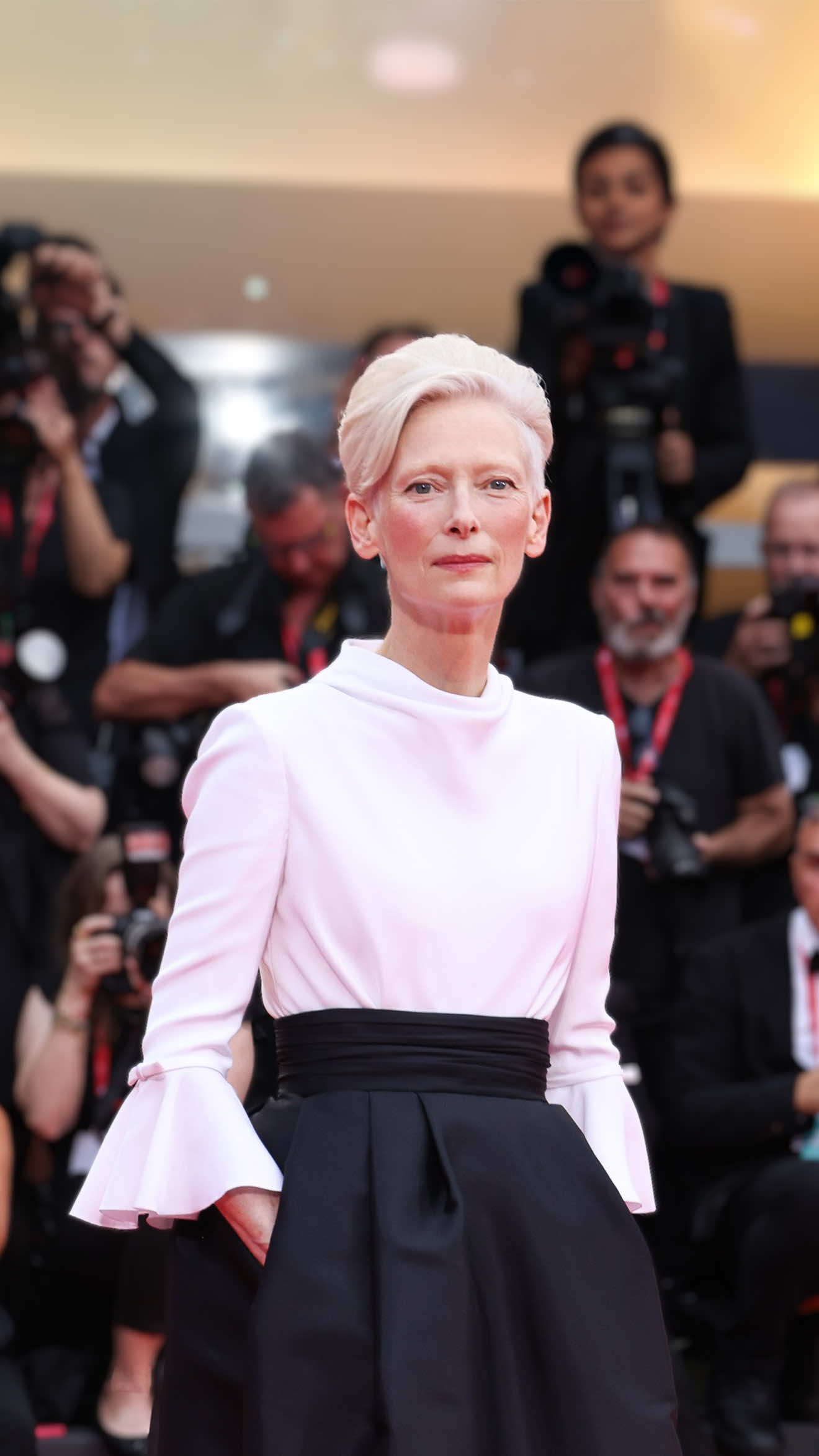 Eterea, sofisticata, anticonvenzionale, in una sola parola: Tilda Swinton. Sbarcata in Laguna, l’attrice questa sera ha calcato il tappeto rosso che ha preceduto la cerimonia d'apertura dell'82ª edizione del Festival di Venezia, dimostrando di non sbagliare mai un colpo, né sul grande schermo né in fatto di scelte stilistiche. Sempre impeccabile e fedele al suo stile, per questo red carpet l'attrice ha indossato un ensemble black and white composto da una parte superiore all'insegna dell'austerity più sartoriale e sopraffina in bianco, con sofisticata chiusura con bottoni sul retro e rouches sugli orli delle maniche, mentre il sotto è stato caratterizzato da un'ampia gonna a ruota strutturata e resa ancora più elegante dalla fascia in vita in raso drappeggiato. In occasione della kermesse, Tilda prenderà parte alla presentazione del suo nuovo film Broken English, un “coraggioso ritratto documentaristico dell’inimitabile cantante, cantautrice e icona Marianne Faithfull”, realizzato con il pieno coinvolgimento dell’artista stessa. ————————— Ethereal, sophisticated, unconventional, in one word: Tilda Swinton. Landed in the Lagoon, the actress this evening walked the red carpet that preceded the opening ceremony of the 82nd edition of the Venice Film Festival, demonstrating that she never misses a beat, neither on the big screen nor with her stylistic choices. Always impeccable and faithful to her style, for this red carpet the actress wore a black and white ensemble composed of an upper part in the name of the most sartorial austerity and refined in white, with a sophisticated button closure on the back and ruffles on the edges of the sleeves, while the bottom was characterized by a wide structured full skirt made even more elegant by the draped satin waistband. During the kermesse, Tilda will take part at the presentation of her new film Broken English, a “courageous documentary portrait of the inimitable singer, songwriter and icon Marianne Faithfull”, created with the full involvement of the artist herself. [📷 IPA] #whoopsee #venezia82 #tildaswinton 