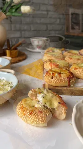 ميني سميت بالجبنة 🧀♥️ Mini smit with Cheese 🧀♥️ العجينة | Dough: ٥٠٠ جرام دقيق (500g flour) ٣٠٠ مل ماء دافئ (300ml warm water) ١ معلقة كبيرة سكر (1 tbsp sugar) ١ معلقة كبيرة خميرة (1 tbsp yeast) ١/٣ كوب زيت زيتون (⅓ cup olive oil) ١ معلقة صغيرة ملح (1 tsp salt) الحشوة | Filling: ٢٠٠ جرام جبنة كريمي ثوم وبقدونس (200g garlic & parsley cream cheese) ١٠٠ جرام موزاريلا (100g mozzarella) ٢ معلقة كبيرة حليب (2 tbsp milk) التغطية | Coating: ١ كوب سمسم محمص (1 cup toasted sesame) ٢ معلقة كبيرة دبس تمر + ١/٤ كوب ماء (2 tbsp molasses + ¼ cup water) التسوية | Baking: ١٨٠° م / 350f 🔥 ١٠ دقايق لحد ما  تبقى دهبي. #baking #simit #minipizza #foodtiktok #مخبوزات 