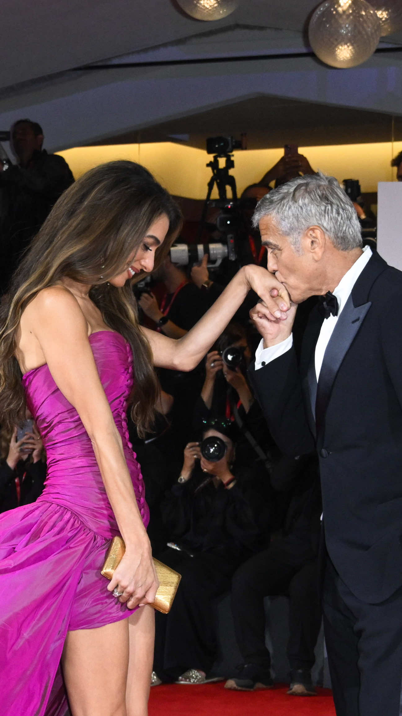 Ci ha pensato la pioggia a rendere tutto più complicato, oppure a rendere ancor più poetico il cielo di Venezia durante questa seconda serata dell’82ª Mostra Internazionale d'Arte Cinematografica. Dove il nome più gridato è sicuramente uno: quello di George Timothy Clooney. Più forte della sinusite e del tempo instabile, l’attore ha presenziato alla première di “Jay Kelly”, film in concorso di Noah Baumbach con un cast d’eccezione. Ma inevitabilmente l’attenzione è andata soprattutto su di lui e sull’inseparabile moglie Amal Clooney, sempre chic, con un corset dress color ciclamino e dalla texture increspata e cangiante, impreziosito dalla chiusura frontale con bottoni e dal design asimmetrico, con gonna mini sul davanti e lunghezze extra sul retro, per uno strascico vaporoso di sicuro effetto. Quasi a sfidare il vento che sembra farlo sventolare, prima del “pronto intervento” di Clooney.  Vi piacciono? ————————— The rain made everything more complicated, or perhaps even more poetic, over the Venice sky during the second night of the 82nd Venice International Film Festival. And the most talked-about name was surely one: George Timothy Clooney. Stronger than sinusitis and the unstable weather, the actor attended the premiere of “Jay Kelly”, Noah Baumbach’s film with an exceptional cast. But inevitably, the spotlight was on him and his inseparable wife Amal Clooney, always chic in a cyclamen-colored corset dress with a rippled, shimmering texture, enhanced by the front button closure and an asymmetrical design, mini skirt in the front and extra length in the back, creating a voluminous train with guaranteed impact. Almost as if defying the wind that seemed to set it fluttering, before Clooney himself stepped in for a quick “rescue”. Do you like them? [📸 IPA] #whoopsee #georgeclooney #amalclooney #jaykelly #venezia82 