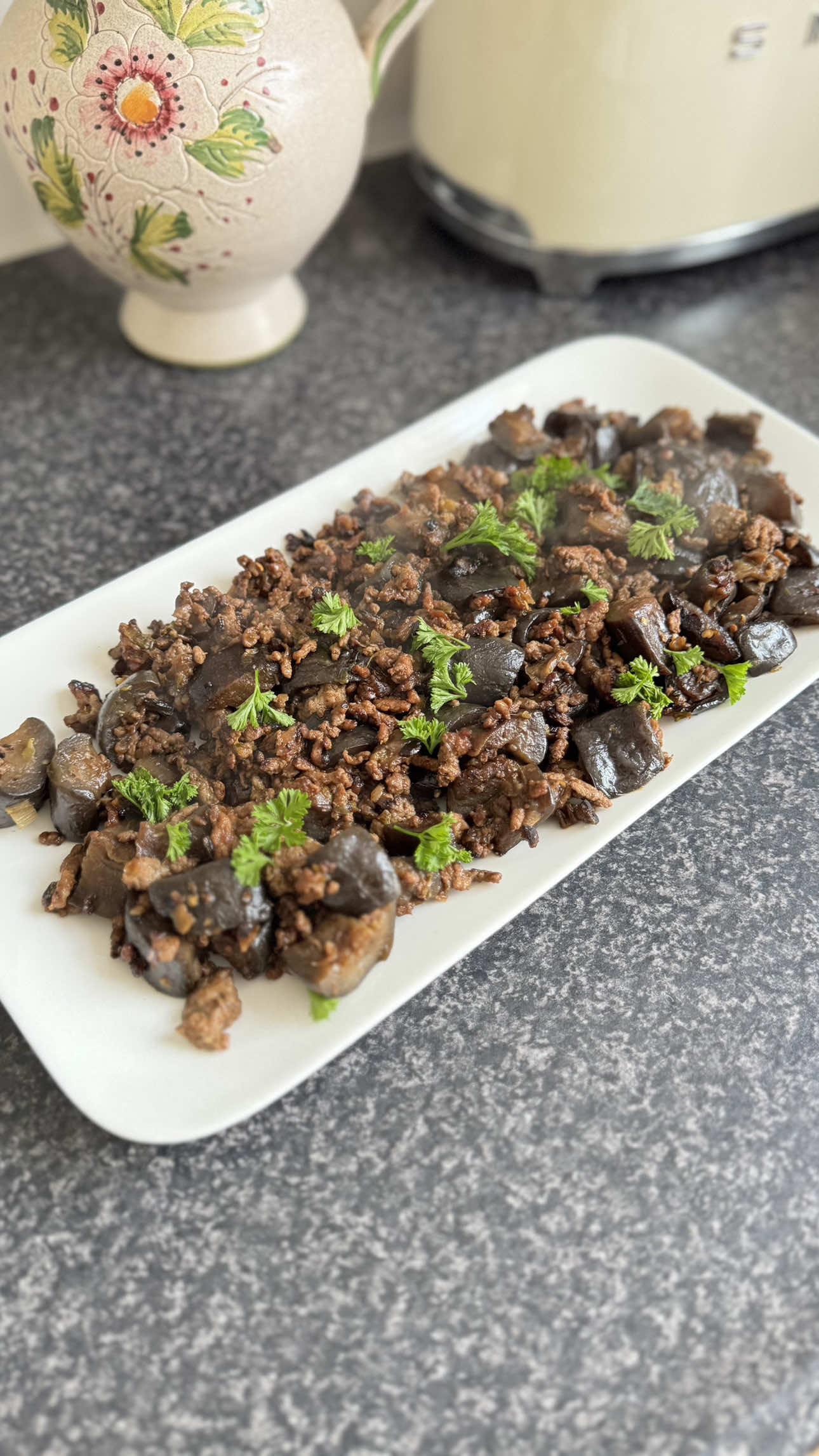 Stir-Fried Eggplant with Minced Chicken Ingredients: • 2 eggplants • 350 g minced chicken • 2 stalks of spring onion • 4 cloves garlic, minced • Salt • 1 tbsp soy sauce • 1 tbsp sweet soy sauce • 1 tbsp teriyaki sauce • 1 tbsp sesame oil • 1/2 tbsp sugar • Fresh parsley Instructions: 1. Wash and cut the eggplants. Sprinkle with salt, let sit briefly, then rinse with water. 2. Chop the spring onions and mince the garlic, then set aside. 3. Heat a pan and cook the minced chicken until half done. Add the spring onions and garlic, then continue cooking until the chicken is fully cooked. 4. Add the eggplants, followed by the seasonings: soy sauce, sweet soy sauce, teriyaki sauce, sesame oil, pepper, and sugar. Cook until the eggplants turn soft. 5. Transfer to a serving plate, sprinkle with parsley, and serve warm. Selamat makan 🫶🏻 #resepterong #whatsfordinner #dinneridea #eggplantrecipe