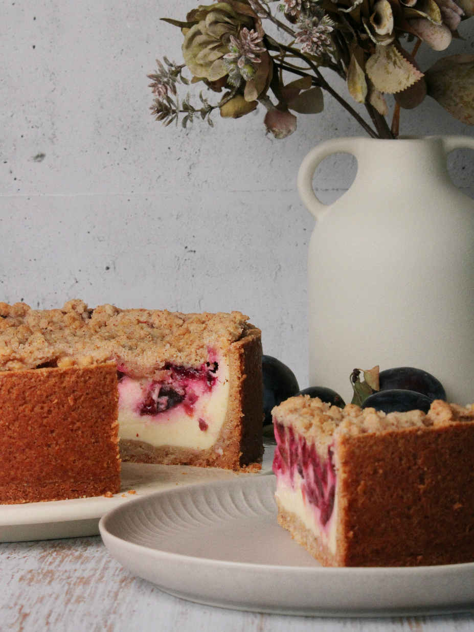 Du kannst dich nicht entscheiden, ob du Lust auf Käse-, Zwetschgen- oder Streuselkuchen hast? Hier bekommst du einfach alles in einem Stück! Diese spätsommerliche Kuchenvariante ist das perfekte Zusammenspiel aus saftig-säuerlichen Zwetschgen, cremiger Quarkcreme und einer Schicht goldbrauner Zimt-Nussstreusel, die beim Reinbeißen herrlich knuspern. Warum sich entscheiden, wenn man alles haben kann? Saftig, cremig, fruchtig und knusprig in einem. Genau das macht meinen Zwetschgen-Käsekuchen deluxe aus!💜 Im Reel zeige ich dir auch meinen neuen Hack für einen richtig knusprigen Boden: Den Mürbeteig backe ich zuerst ohne Rand vor. So wird er stabil und behält seine Knusprigkeit auch bei saftigen Füllungen. Danach lässt sich der Rand ganz entspannt hochziehen - ohne Einsacken und ohne das lästige Blindbacken mit Hülsenfrüchten. Kanntest du den Trick schon? Ich freue mich auf dein Feedback ❤️ Für eine 26 cm Springform benötigst du: Mürbeteig: 200 g Mehl 100 g Mandeln oder Haselnüsse, gemahlen 100 g Zucker 100 g Butter, kalt 1 Ei 1/2 TL Zimt Füllung: 500 g Magerquark 200 g Schlagsahne, flüssig 150 g Zucker 2 Eier (Größe M) 1 Pck. Vanillepuddingpulver 85 g Butter, flüssig Belag: 600 g Zwetschgen, nicht entsteint Streusel: 75 g Mehl 75 g Haselnüsse oder Mandeln, gemahlen 75 g Butter, weich 75 g Zucker 1/2 TL Zimt 1 Msp. Backpulver Zum Fetten: Margarine Mehl Boden: 1. Den Boden einer Springform mit Margarine fetten und etwas Mehl ausstäuben. 2. Für den Mürbeteig die kalte Butter in Stücke schneiden und mit den restlichen Zutaten zu einem glatten Teig verkneten. 3. Ca. zwei Drittel des Teiges als Boden in die Springform drücken. Noch keinen Rand hochziehen. Den restlichen Teig bis zur weiteren Verwendung kaltstellen. 4. Den Boden mehrmals mit einer Gabel einstechen und für ca. 10 min bei 160°C Umluft vorbacken. Vollständig auskühlen lassen. 5. Aus dem restlichen Teig einen ca. 5 cm hohen Rand auf dem vorgebackenen Boden hochziehen. Streusel: Alle Zutaten zu Streuseln verkneten. Belag: Die Zwetschgen waschen, entsteinen und klein schneiden. Füllung: 1. Butter in einem Topf bei niedriger Hitze schmelzen. Zum Abkühlen auf die Seite stellen. 2. Alle Zutaten für die Füllung, auch die geschmolzene Butter, in eine Schüssel geben und von Hand mit einem Schneebesen zusammenrühren. Nur solange rühren, bis sich alles zu einer glatten Masse verbunden hat. Fertigstellung: 1. Die Masse in die Springform füllen. Zuerst die Zwetschgen, dann die Streusel darauf verteilen. 2. Den Kuchen bei 150°C Umluft ca. 70 min backen. Nach Ende der Backzeit den Kuchen für ca. 30 min bei leicht geöffneter Tür im ausgeschalteten Backofen stehen lassen. Das klappt, indem du einen Kochlöffel in die Tür klemmst. Erst danach bei Zimmertemperatur auskühlen lassen. Dadurch ist der Temperaturunterschied nicht so groß. 3. Vollständig auskühlen lassen, bevor der Kuchen aus der Form gelöst wird. Viel Spaß beim Nachbacken❤️ Wenn du Fragen hast, schreib mir gerne 🤗 #käsekuchen #weltbesterkäsekuchen #besterkäsekuchen #zwetschgenkuchen #streusel 