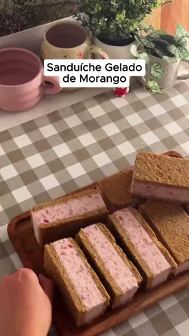Sanduíche Gelado de Morango  Fácil, gelado e sem precisar acender o fogão! 🧡  Ê Ingredientes  Base e cobertura:  600g de bolacha tipo Mana  . 170g de manteiga sem sal derretida  Recheio:  500g de creme de leite fresco (bem gelado)  . l colher de chá de essência de baunilha  . 150g de leite condensado  . 4 colheres de sopa de geleia de morango (fria e firme)  Modo de Preparo no video.  #gelado #receitas #doces 