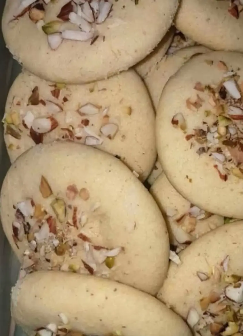 Nankhatai Recipe 🍪 📝 Ingredients: All-purpose flour (Maida) – 1 cup Besan (Gram flour) – 2 tbsp Sooji (Semolina) – 1 tbsp (optional, for texture) Powdered sugar – ½ cup Ghee (clarified butter) – ½ cup (solid/semi-solid) Baking powder – ¼ tsp Cardamom powder – ½ tsp Salt – a pinch Chopped nuts (almonds, pistachios) – for topping 👩‍🍳 Method: 1. Preheat oven to 160°C (320°F). 2. Mix dry ingredients: In a bowl, sift together maida, besan, sooji, baking powder, cardamom powder, and a pinch of salt. 3. Cream ghee and sugar: In another bowl, whisk ghee and powdered sugar until light and creamy. 4. Combine: Gradually add dry ingredients to the ghee-sugar mixture. Mix until it forms a soft dough. Do not knead too much. 5. Shape: Divide into small equal balls, flatten slightly, and place on a baking tray lined with parchment paper. 6. Top with nuts: Gently press chopped nuts on top of each cookie. 7. Bake: Bake for 15–18 minutes or until the edges are lightly golden. The cookies will still be soft; they firm up as they cool. 8. Cool completely before storing in an airtight container. 🍪 Tips: Ensure ghee is solid or semi-solid, not melted. Adjust sugar to taste. For extra flavor, you can add a pinch of saffron or rose essence.