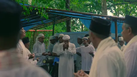 Di pagi yang berselimut kabut hujan,   Langkah-langkah mulai teranyam di tanah leluhur,   Tukang Dua Belas berjalan di depan,   Dengan mata yang tahu arah,   Dengan hati yang tunduk pada warisan. Di tengah barisan, Imam melantunkan ayat,   Suara lembutnya menembus dedaunan,   Menggetarkan batu-batu tua,   Menyatukan langit dan bumi dalam satu zikir. Raja pun melangkah, Upu Latu yang agung,   Dengan pakaian kebesaran dan wajah penuh makna,   Ia bukan hanya pemimpin,   Ia adalah penjaga poros adat dan iman,   Tempat segala arah bermuara. Tiang Alif menanti di hutan suci,   Kayu pilihan yang menyimpan sabda,   Bukan sekadar batang,   Ia adalah lambang:   Tegak lurus menuju Tuhan,   Berakar dalam tanah warisan. Tifa berdentum pelan, tahuri bersahut jauh,   Langkah mereka bukan hanya perjalanan,   Tapi pernyataan:   Bahwa adat masih hidup,   Bahwa iman masih menyala,   Bahwa Kaitetu masih ingat jalannya.