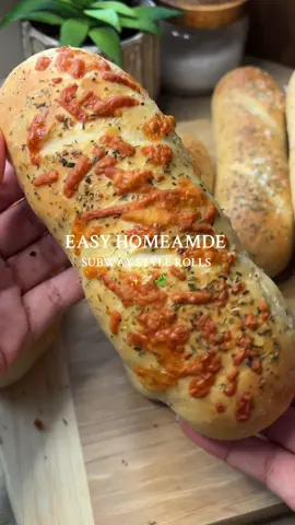 Homemade Sub Rolls ✨🥖 Here’s The Full Recipe👇🏽:  Ingredients 500g strong white bread flour 10g salt 20g sugar 7g instant yeast (1 packet) 20g olive oil (or neutral oil) 300ml warm water (adjust if needed) 1-2tbsp water + 1-2tbsp milk (for brushing over before baking)  Toppings: Italian herb seasonings, grated cheese of choice, flaky sea salt (optional)  Method 	1.	Mix flour, yeast, sugar, and salt. 	2.	Add warm water + oil, knead 8–10 mins until smooth and stretchy. 	3.	Cover and let rise until doubled (about 1 hr). 	4.	Divide into 6 equal pieces (~135g each). 	5.	Roll each into a 6-inch log (slightly tapered ends for the Subway look). 	6.	Place on a tray with parchment, cover, proof 30–40 mins until puffy. 	7.	Brush tops with a mix of water and milk and score each roll with a knife (be light handed, don’t score too deep!)  	8.	Bake at 200°C (fan 180°C) for 15–18 mins until golden and hollow-sounding. 	9.	Cool before slicing. #EasyRecipe #bread #baking #bakingrecipe #breadrecipe 